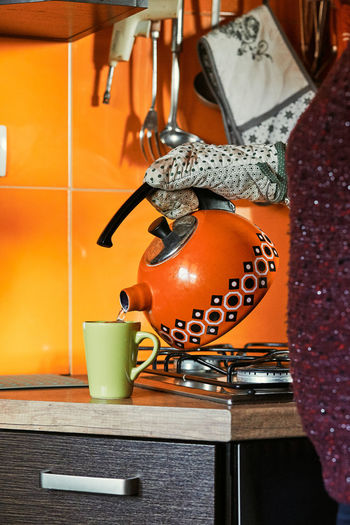 Midsection of woman pouring water into cup