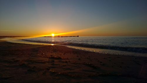 Scenic view of beach against sky during sunset