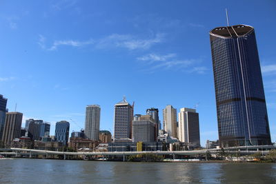 Sea by cityscape against sky