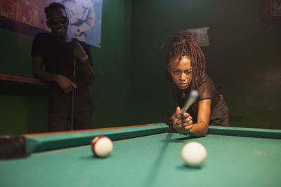 A young woman playing pool.