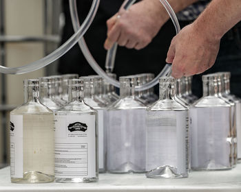 Close-up of hand holding glass bottles