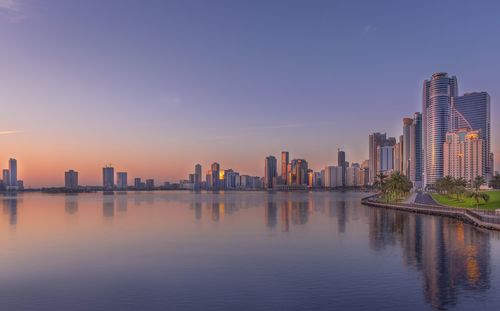 Emirate of sharjah by lake against sky during sunset