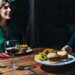 Cropped hand of waiter keeping food on table in restaurant