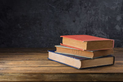 Close-up of books on table against wall