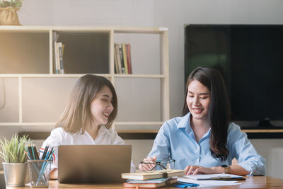 Portrait of smiling friends working at creative office