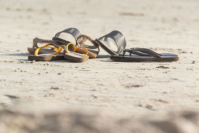 Close-up of shoes on beach