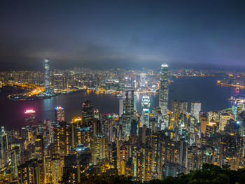 Illuminated cityscape against sky at night