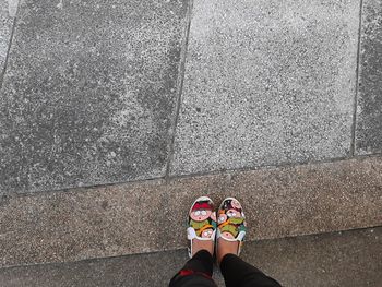 Low section of woman standing on footpath