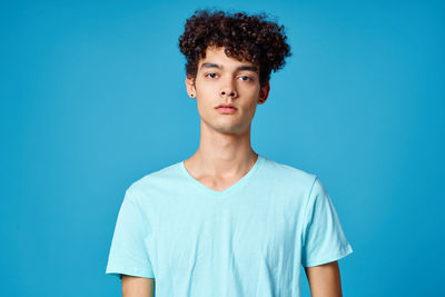 Portrait of young man against blue background