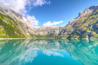 Scenic view of lake by mountains against sky