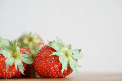 Close-up of strawberries on table against white background