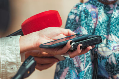 News reporters interviewing an unrecognizable people outdoors