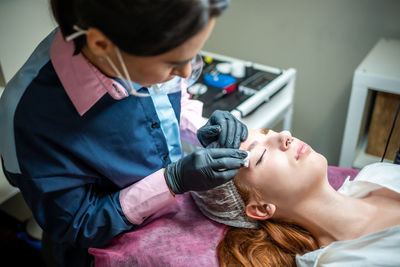 High angle view of doctor examining patient at home