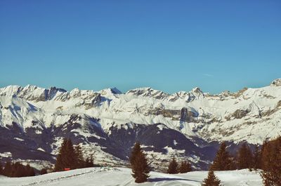 Scenic view of snowcapped mountains against clear sky