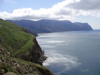 Scenic view of sea and mountains against sky