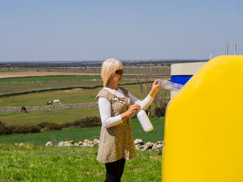 Full length of woman standing on field against clear sky