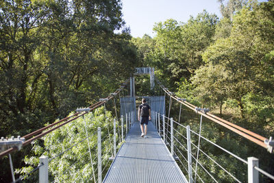 Rear view of people walking on footbridge