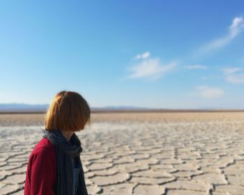 Woman on salt flat against sky