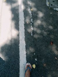 Low section of person standing on street during rainy season