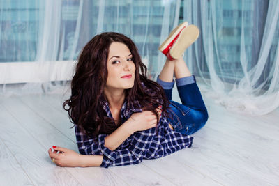 Portrait of beautiful woman lying down on floor