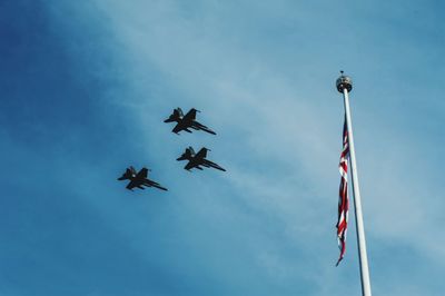 Low angle view of malaysian flag and airplane against sky