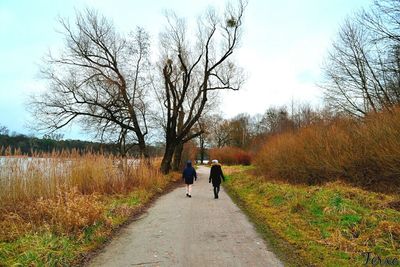 Rear view of woman walking on footpath