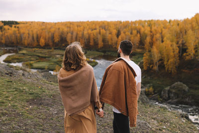 Happy people in love are travel hike in nature in the autumn forest. romantic trip to countryside