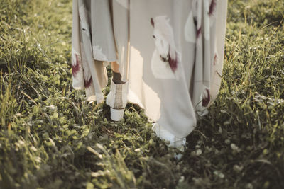 Low section of woman standing on field