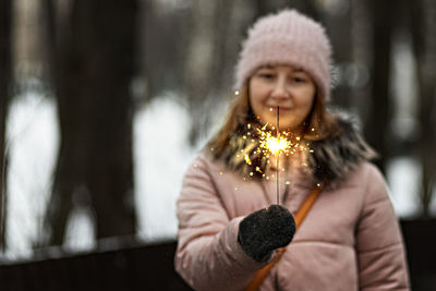 Christmas lights are bright splashes burning in the hands of a blurry happy woman.sparkler. 