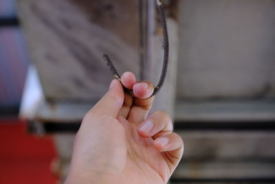 Close-up of hand holding rusty metal