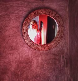 Reflection of woman on red mirror