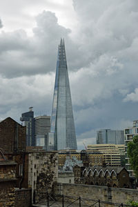 Low angle view of buildings against cloudy sky