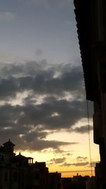 Low angle view of silhouette buildings against sky