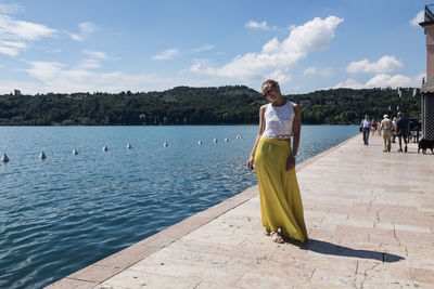 Young woman in casual clothing standing on harbor