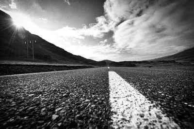 Surface level of road by mountain against sky