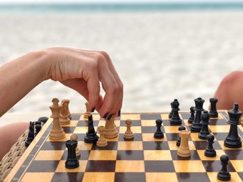 Cropped hand of woman playing chess outdoors