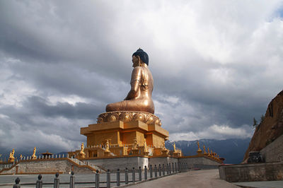 Low angle view of statue against temple against sky