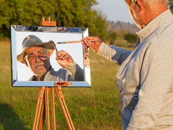 Rear view of man holding book