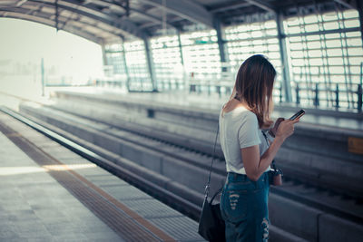 Woman standing on railroad station platform