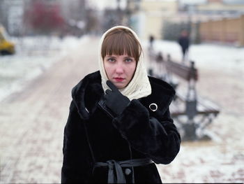 Portrait of young woman standing in snow
