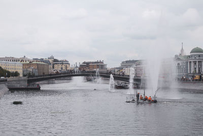 View of boats in river with buildings in background