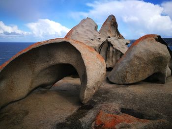 Scenic view of rocks on beach against sky