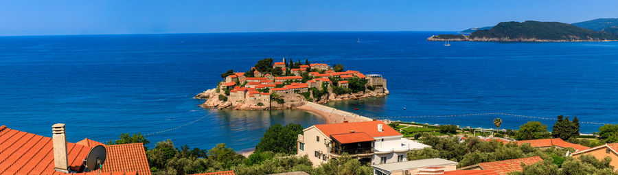 High angle view of townscape by sea against sky