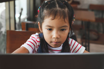 Schoolgirl looking at laptop in classroom