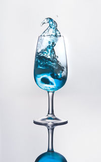 Blue wine splashing against gray background