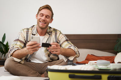 Portrait of senior man using mobile phone while sitting at home