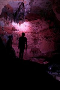 Silhouette of man standing in cave