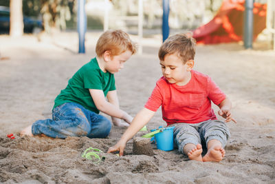 Boys playing with sand at playground
