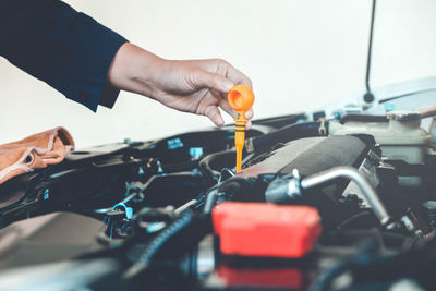 Cropped hands of mechanic repairing car in garage