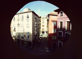 Buildings against sky seen through window